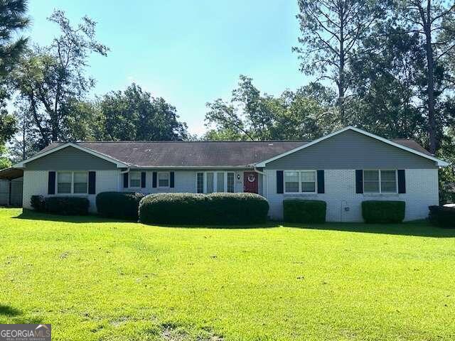 a front view of a house with yard and tree