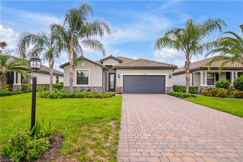 a front view of a house with a garden and palm trees