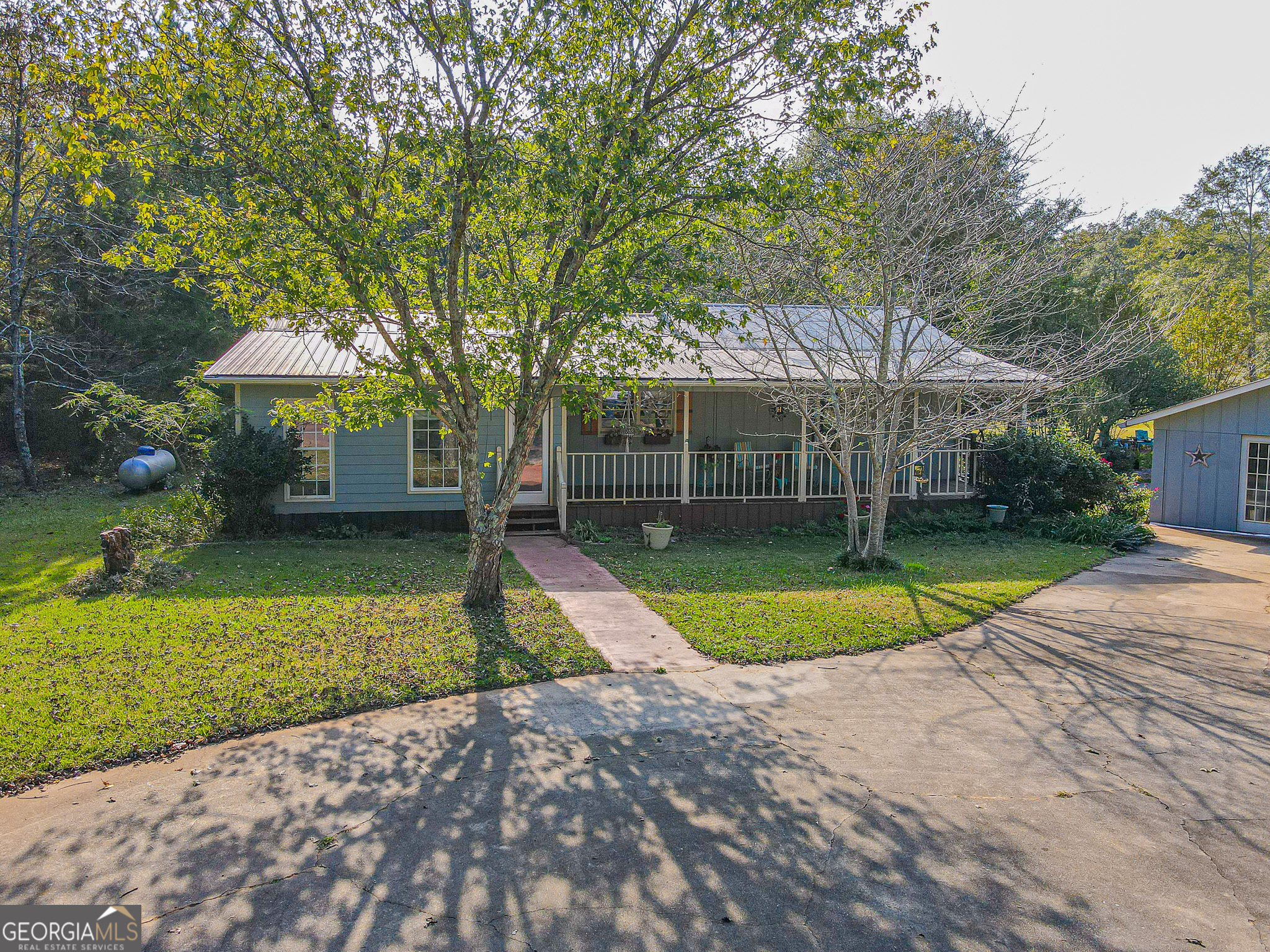 a view of a house with backyard and trees