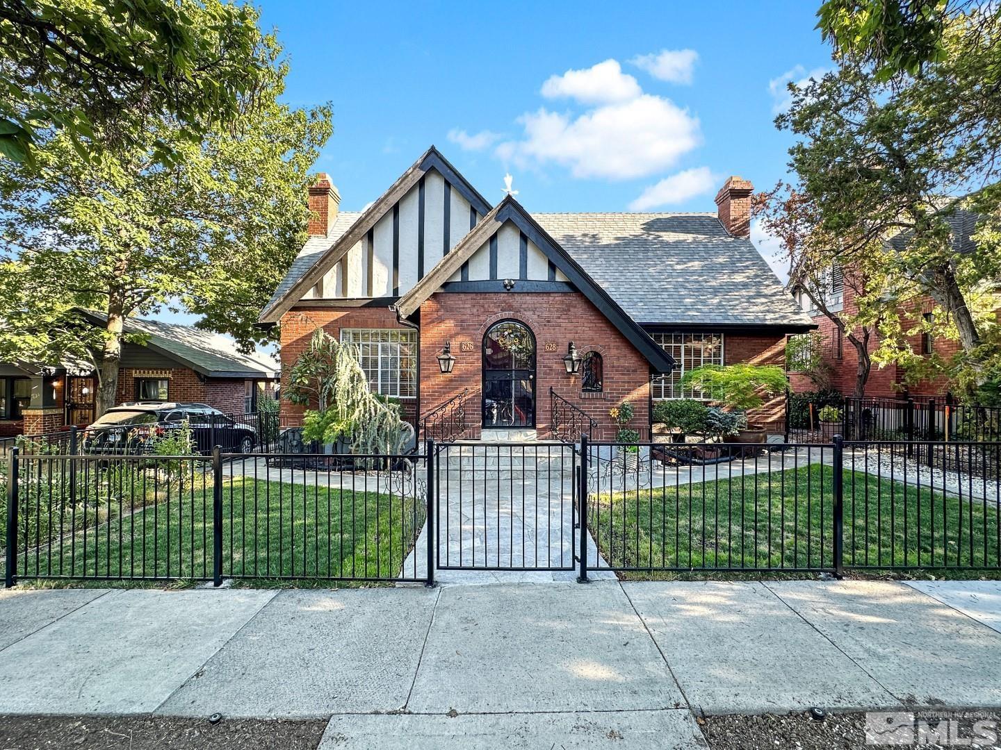 a view of a house with a small yard and a fence