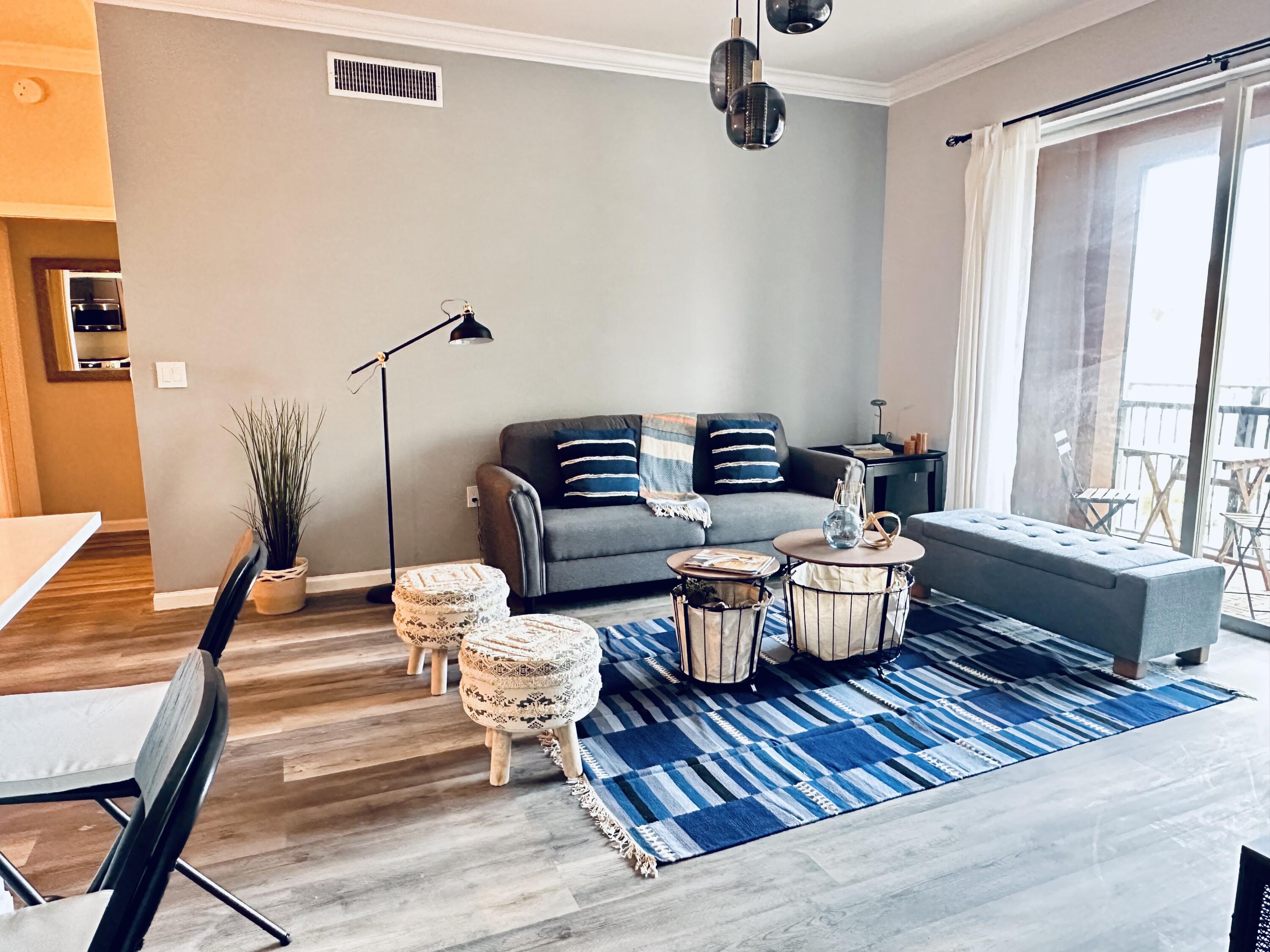 a living room with furniture a rug and a large window