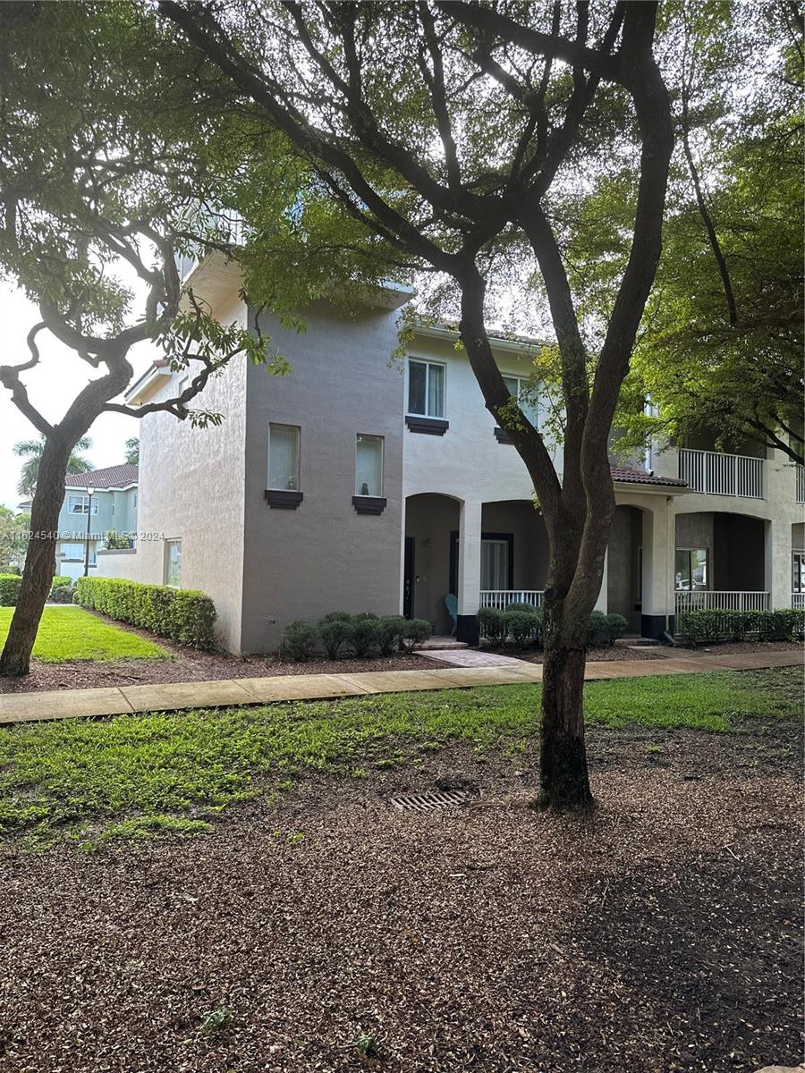 a house that has a tree in front of a white house