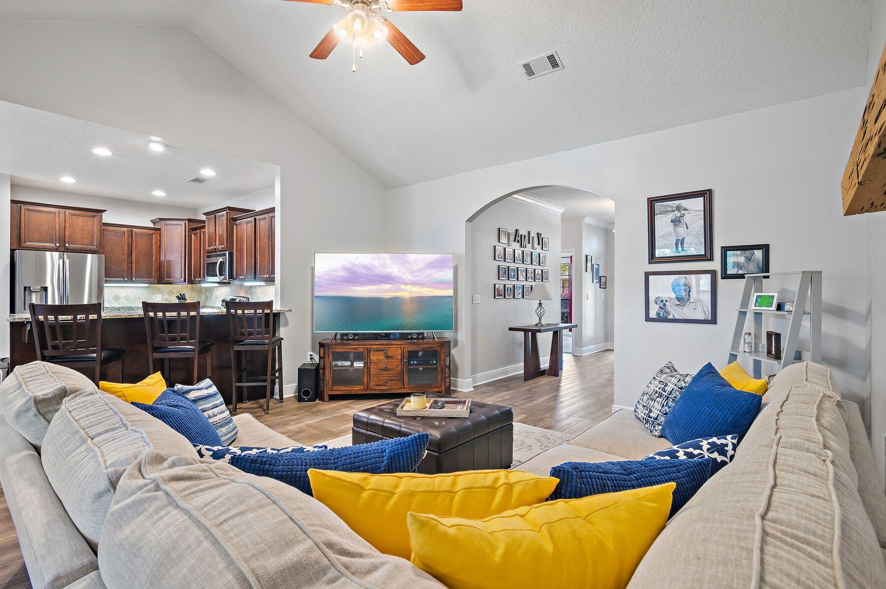 a living room with furniture kitchen view and a large window