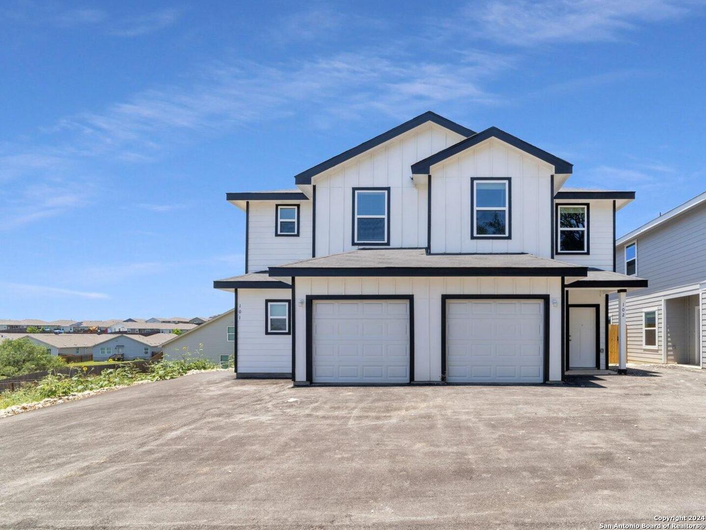 a front view of a house with a yard and garage