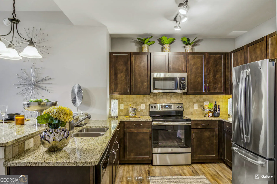 a kitchen with stainless steel appliances granite countertop a sink and a refrigerator