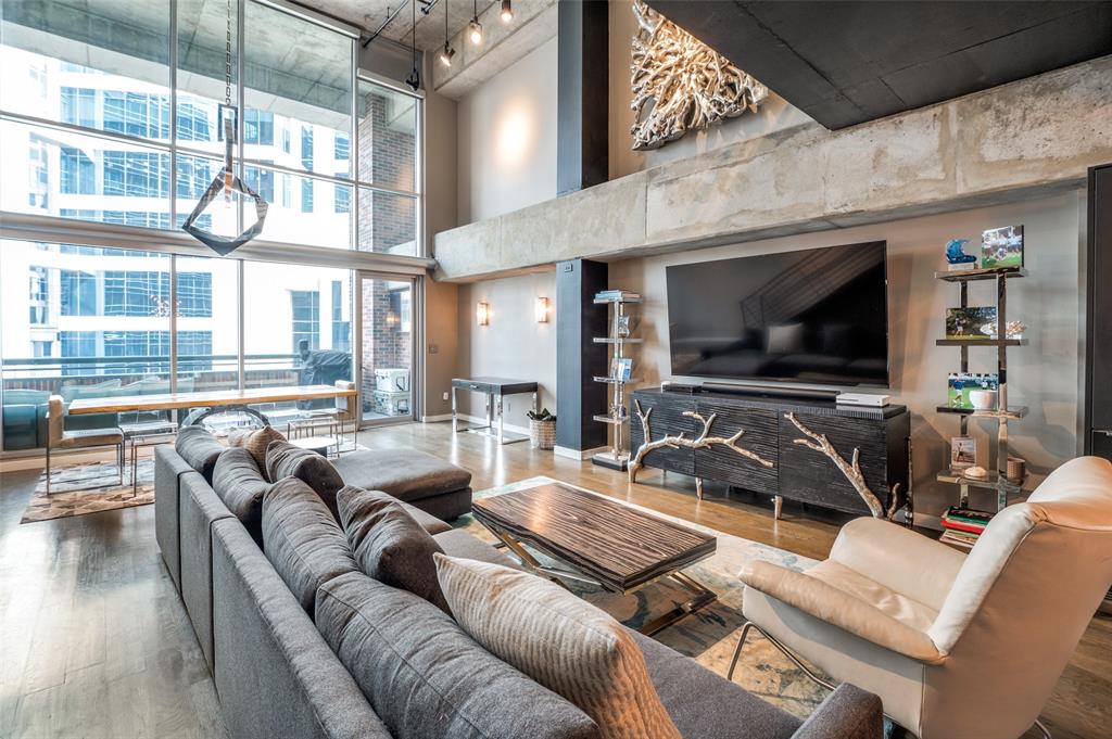 a living room with furniture a flat screen tv and kitchen view