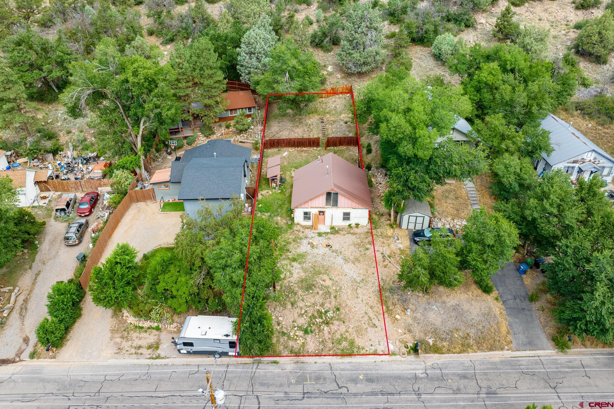 an aerial view of a house with a yard and large tree