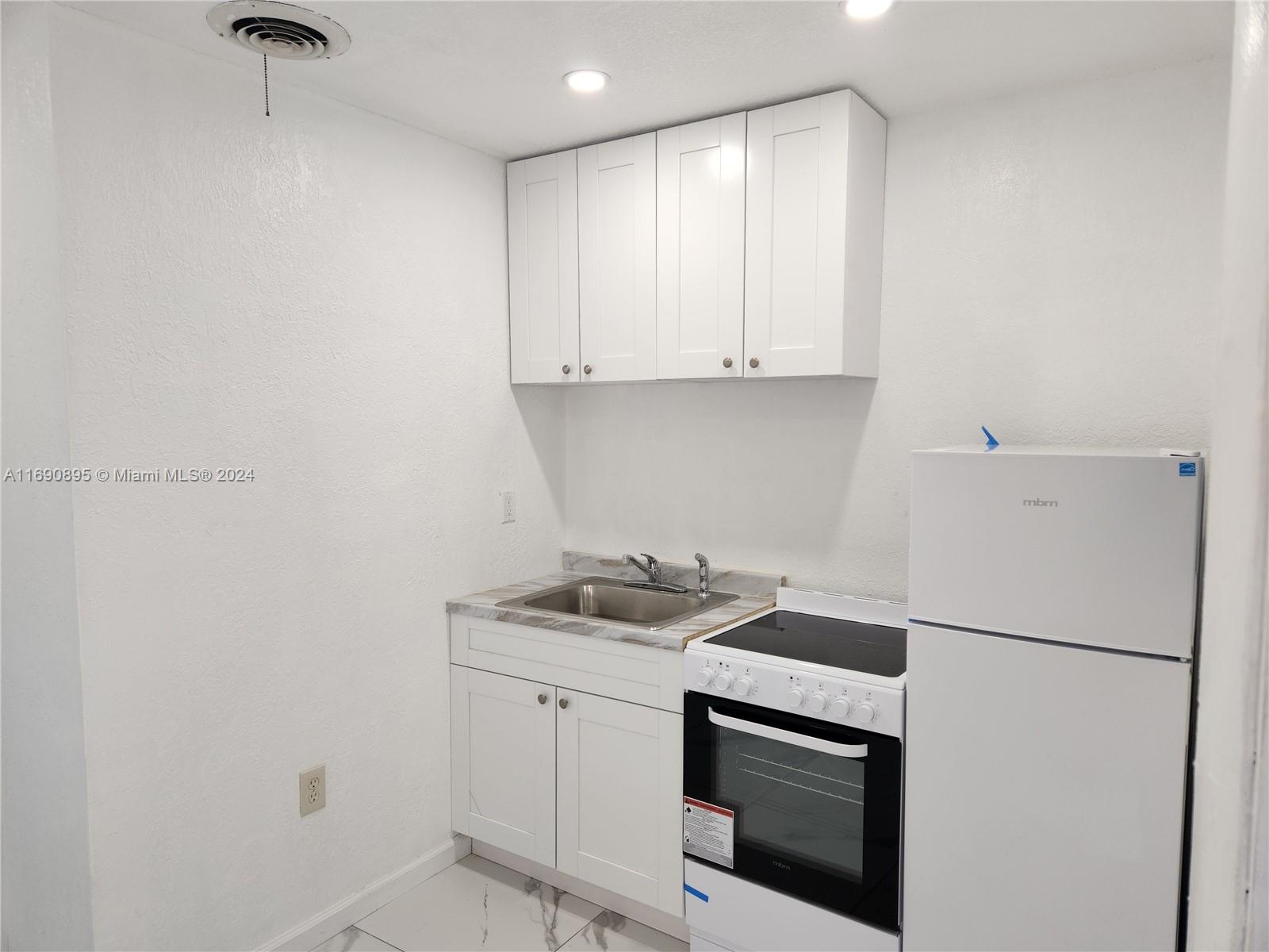 a kitchen with a sink cabinets and stainless steel appliances