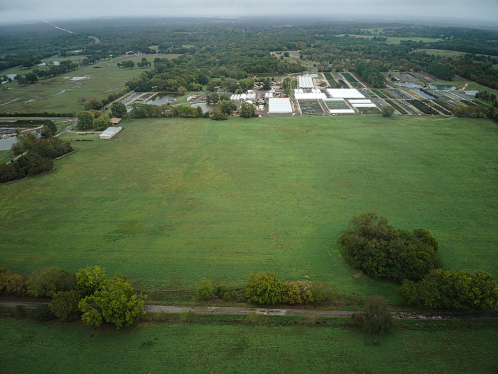 an aerial view of residential houses with outdoor space and trees