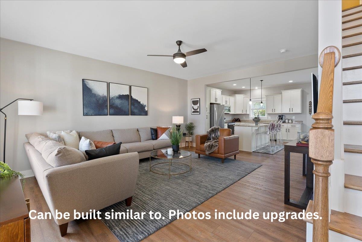 a living room with furniture kitchen view and a chandelier