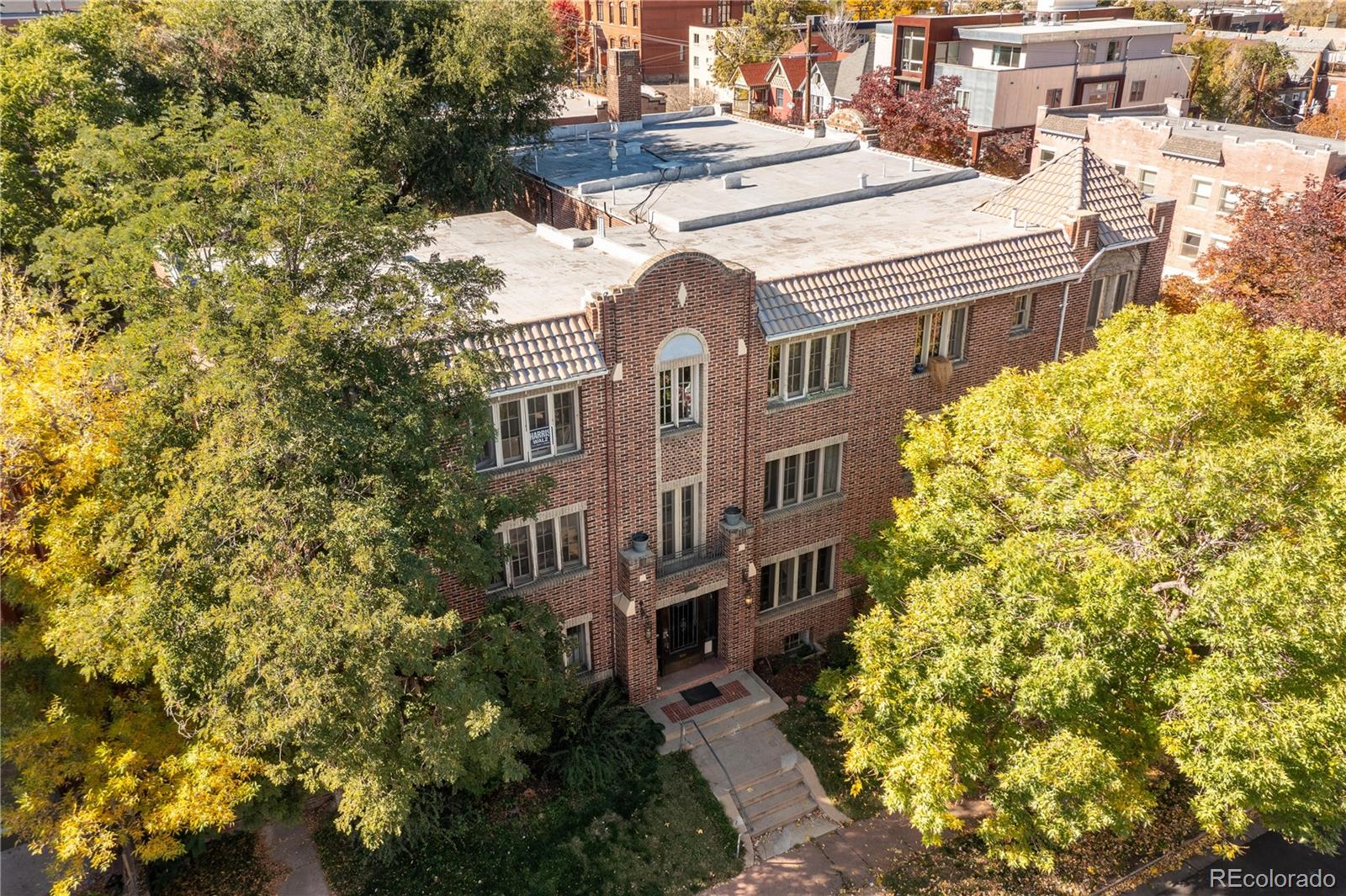 a front view of a multi story residential apartment building with a yard and outdoor seating