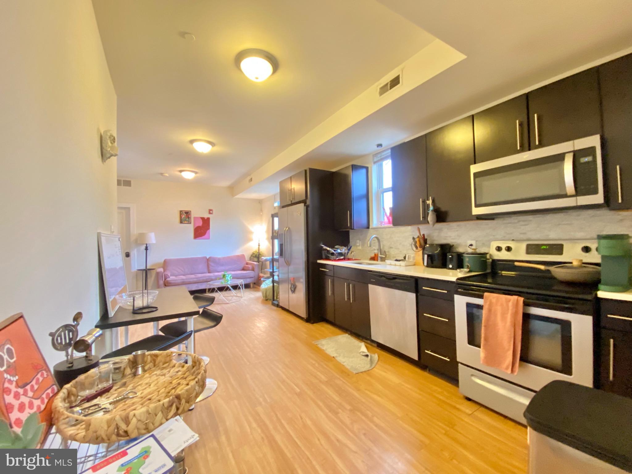 a kitchen with stainless steel appliances kitchen island granite countertop a stove and cabinets