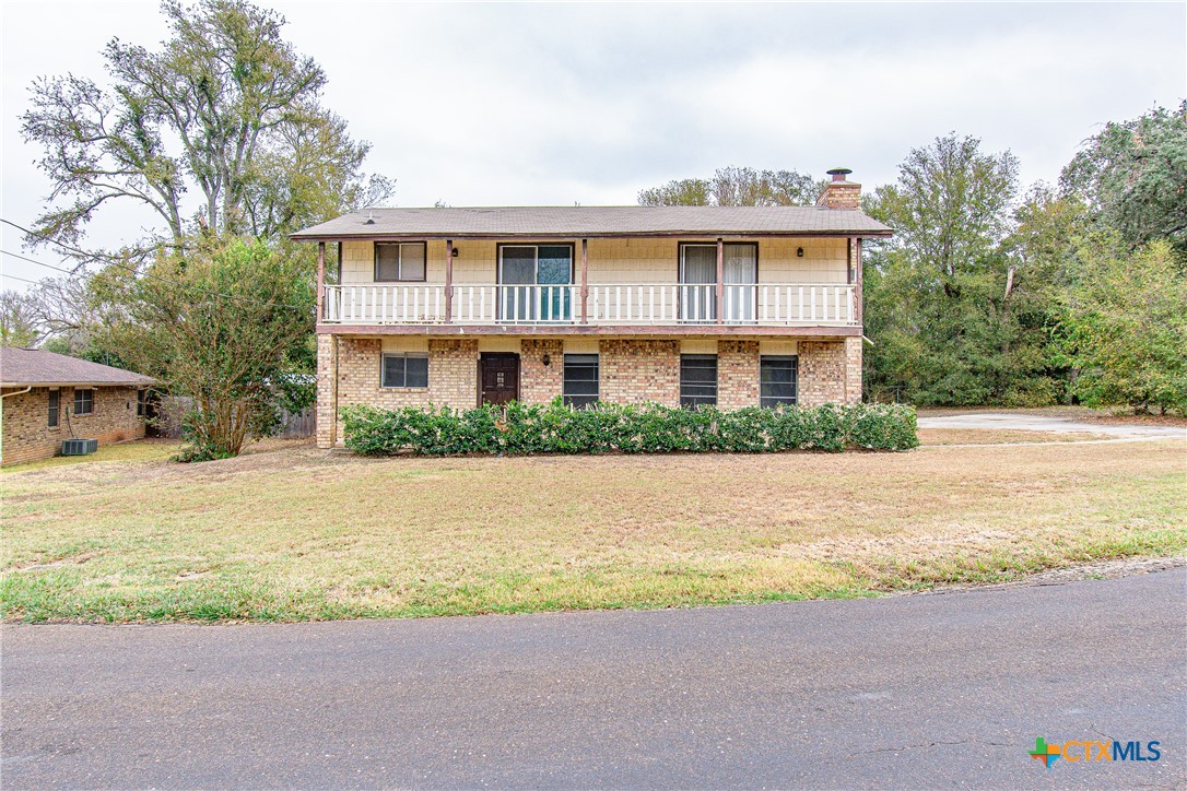 a front view of house with yard and trees around