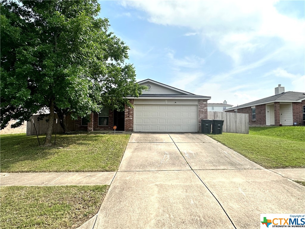 a front view of a house with a yard and trees