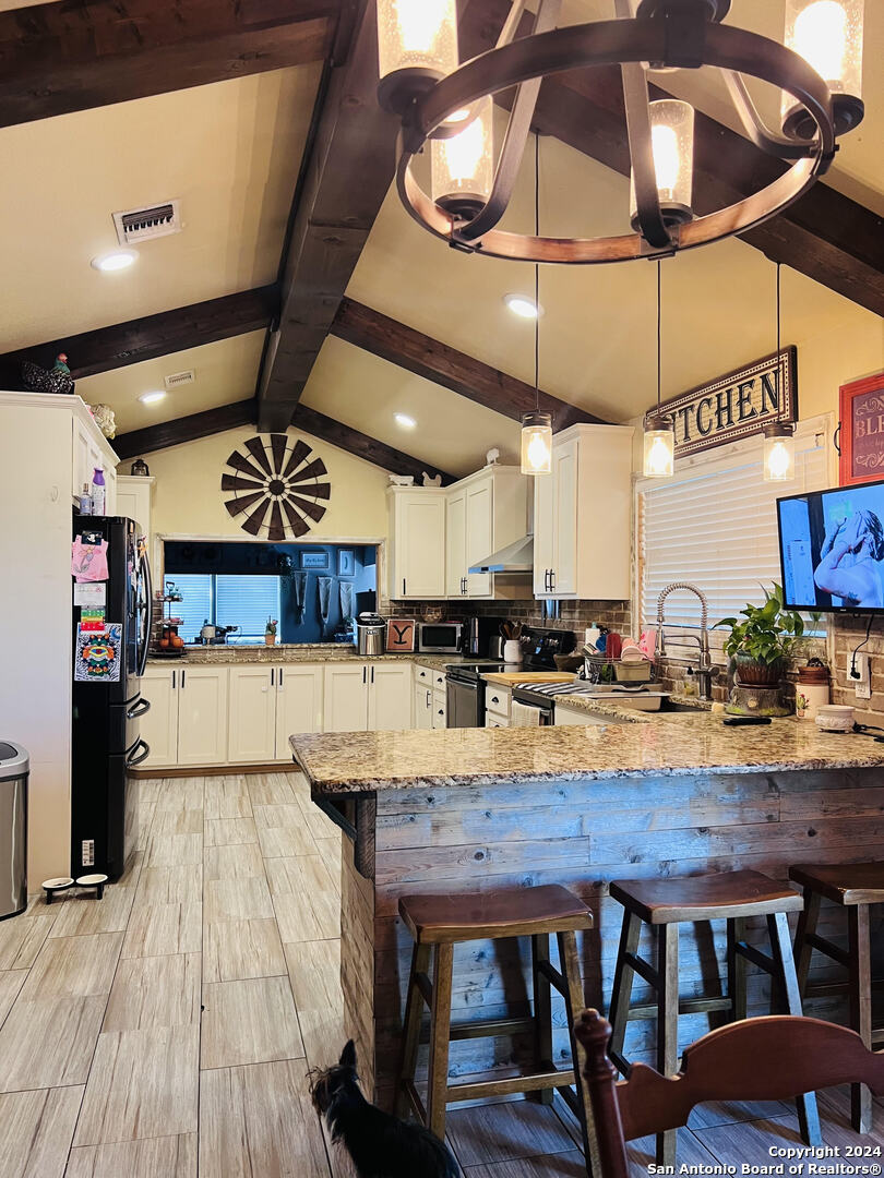 a view of a kitchen with kitchen island a counter space a sink and appliances