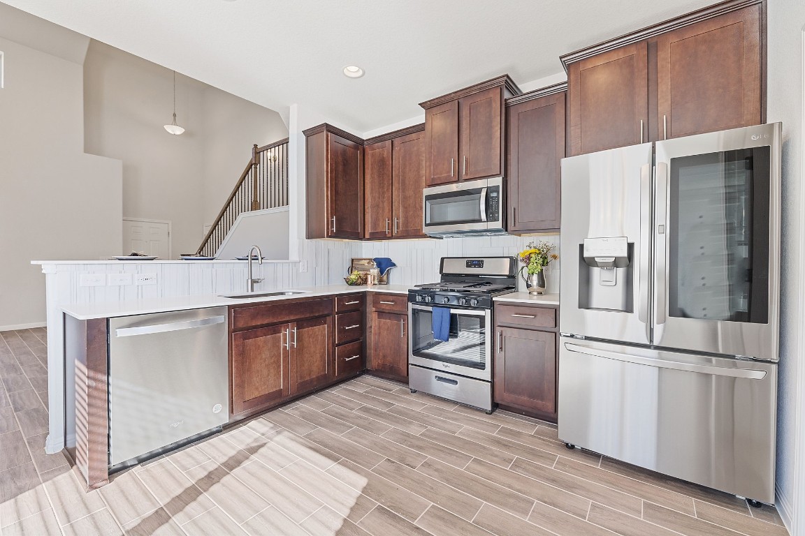 a kitchen with a refrigerator cabinets and wooden floor