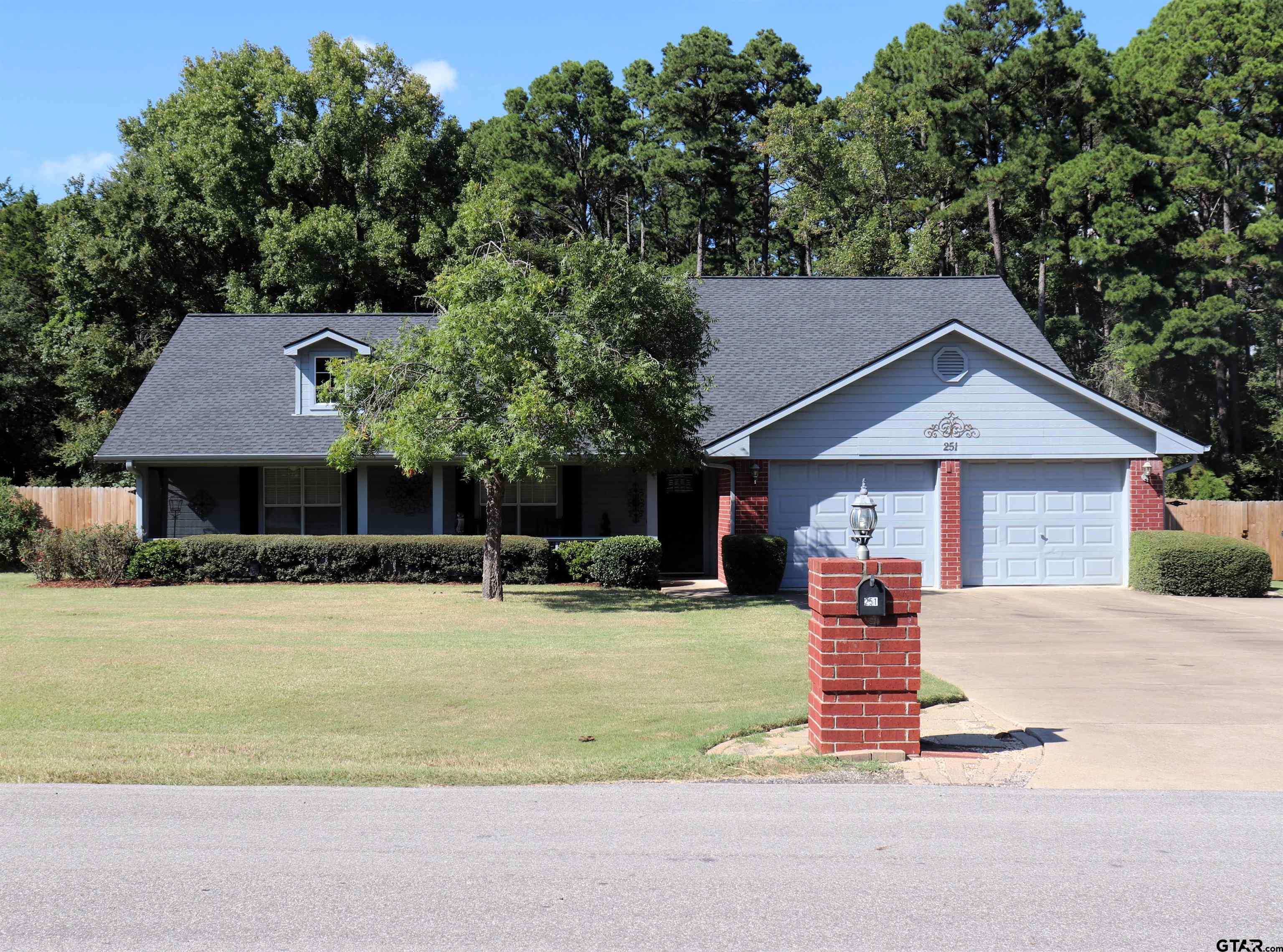 a front view of house with yard and trees in the background