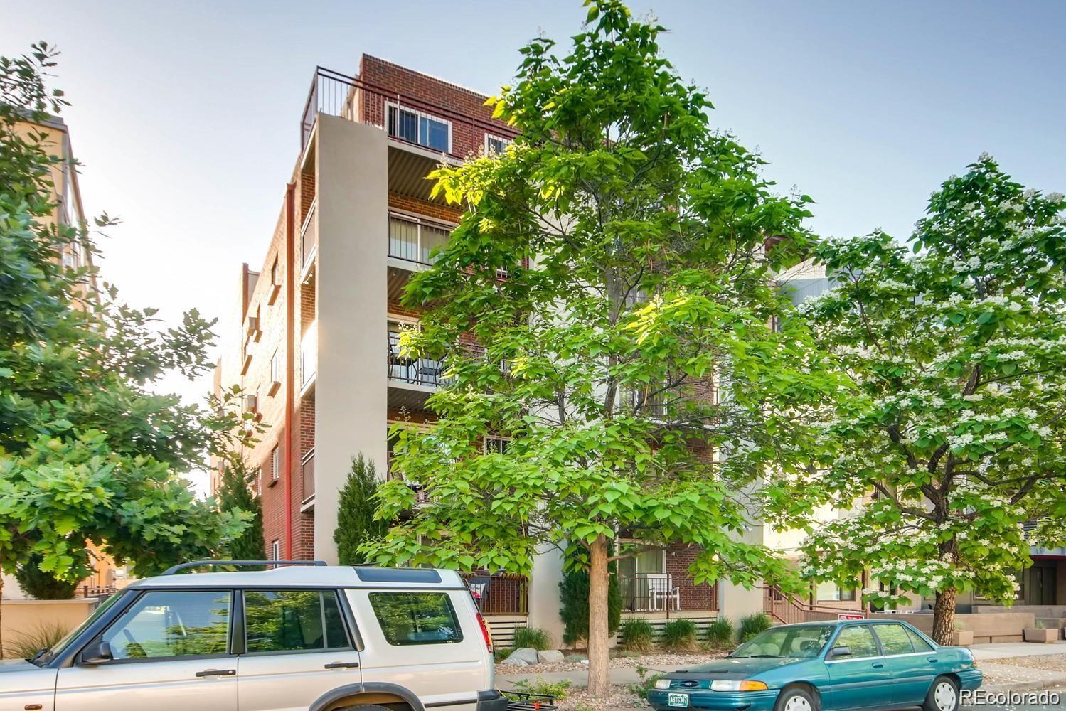 a front view of a building with trees