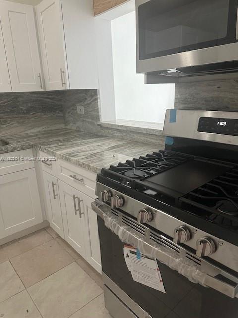 a stove top oven sitting inside of a kitchen