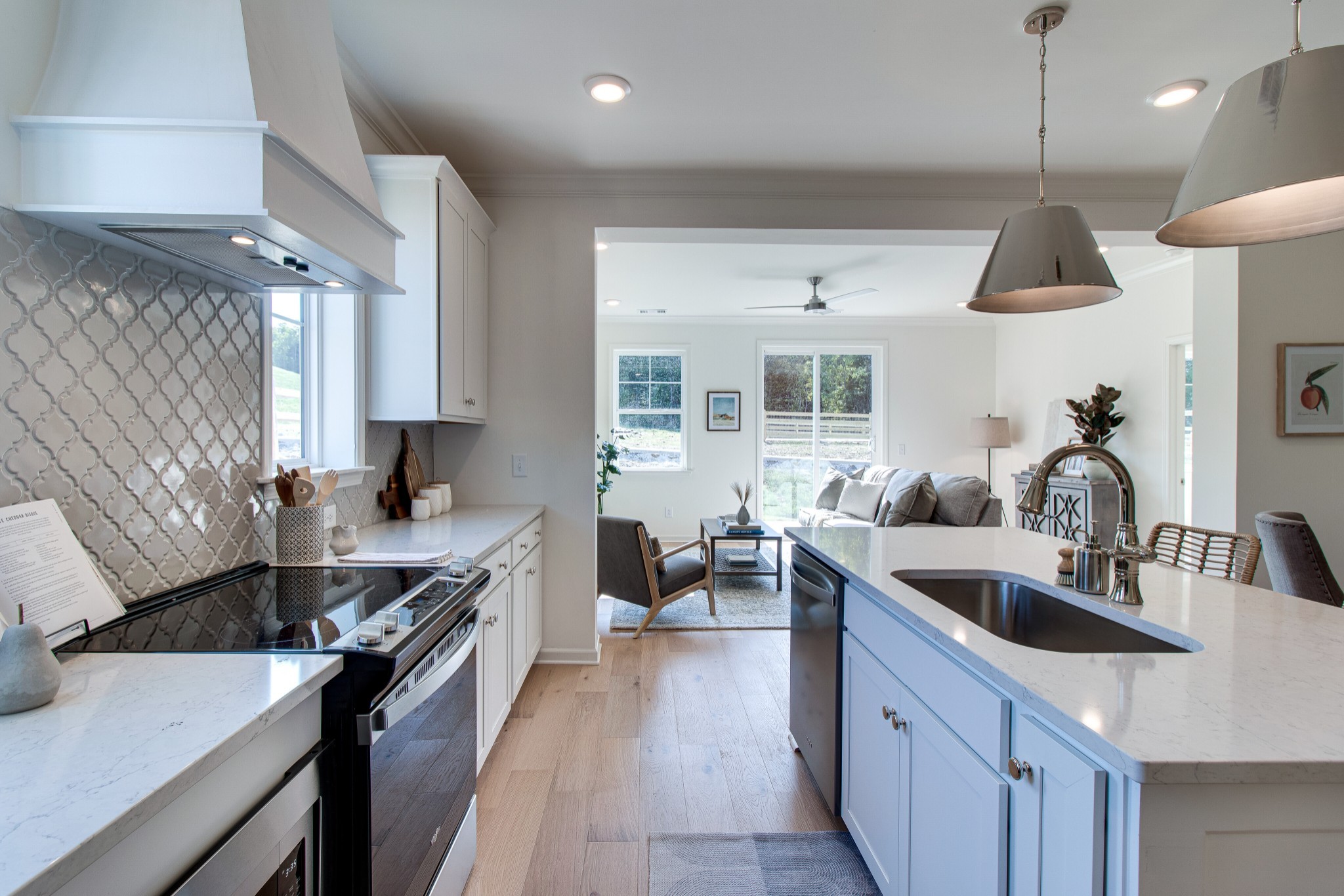 a kitchen with stainless steel appliances granite countertop a sink a stove and a wooden floors