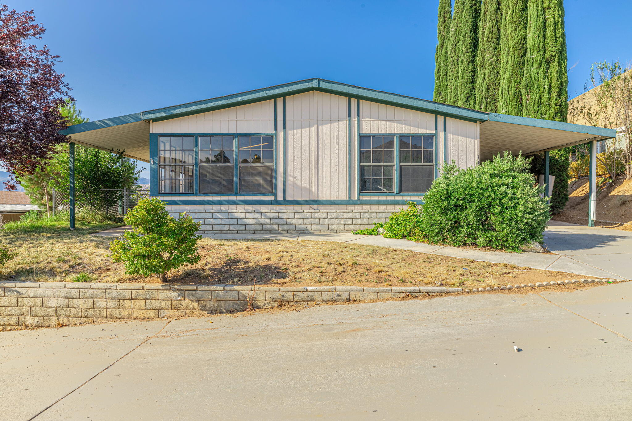 a front view of a house with a yard and potted plants