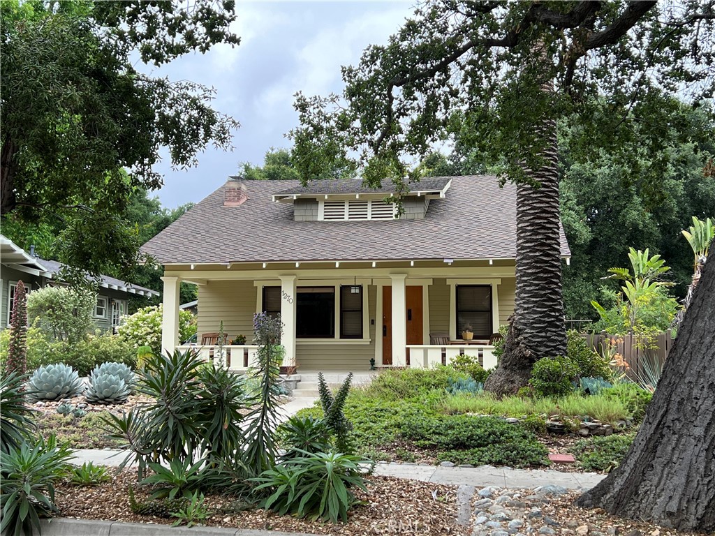 a front view of a house with plants and trees