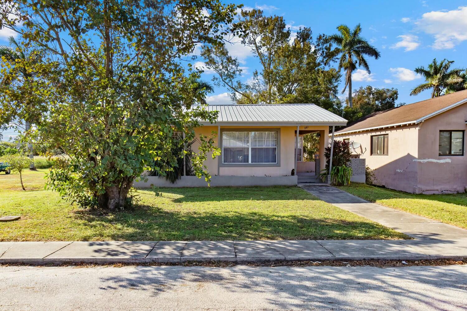 a front view of a house with a garden and yard