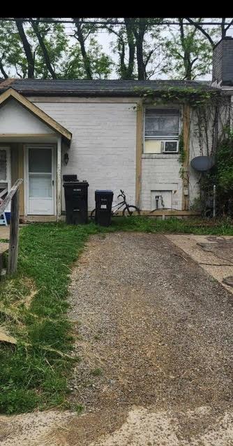 a view of a house with a yard and a large tree