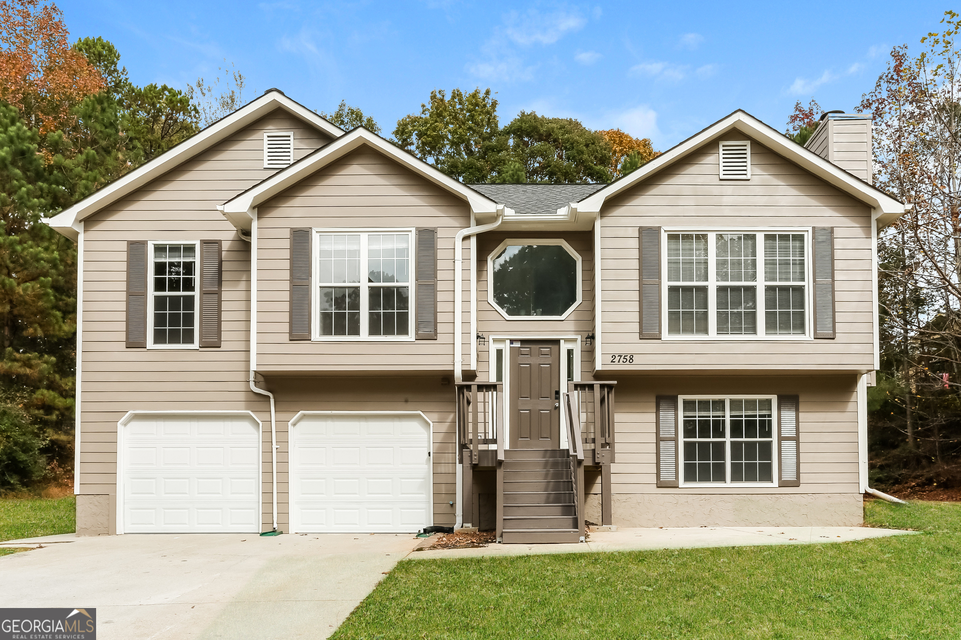 a front view of a house with a yard and garage