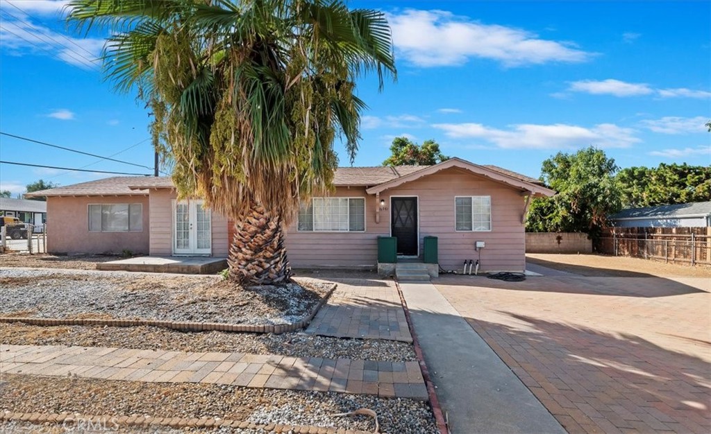 a front view of a house with a yard and tree