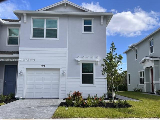 a front view of a house with a yard and garage