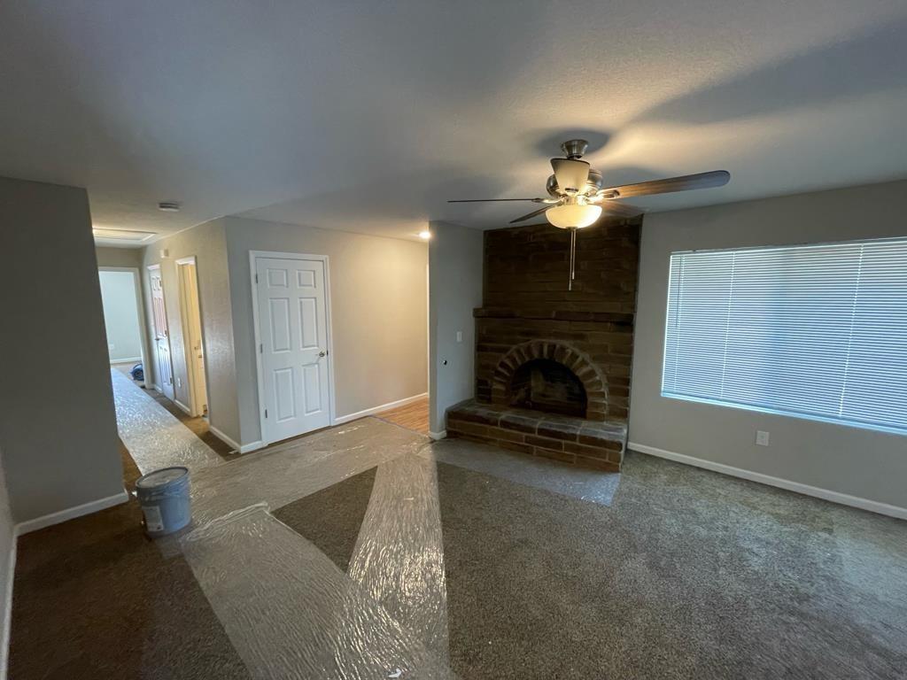 a view of a livingroom with a fireplace a chandelier a wooden floor and a fireplace