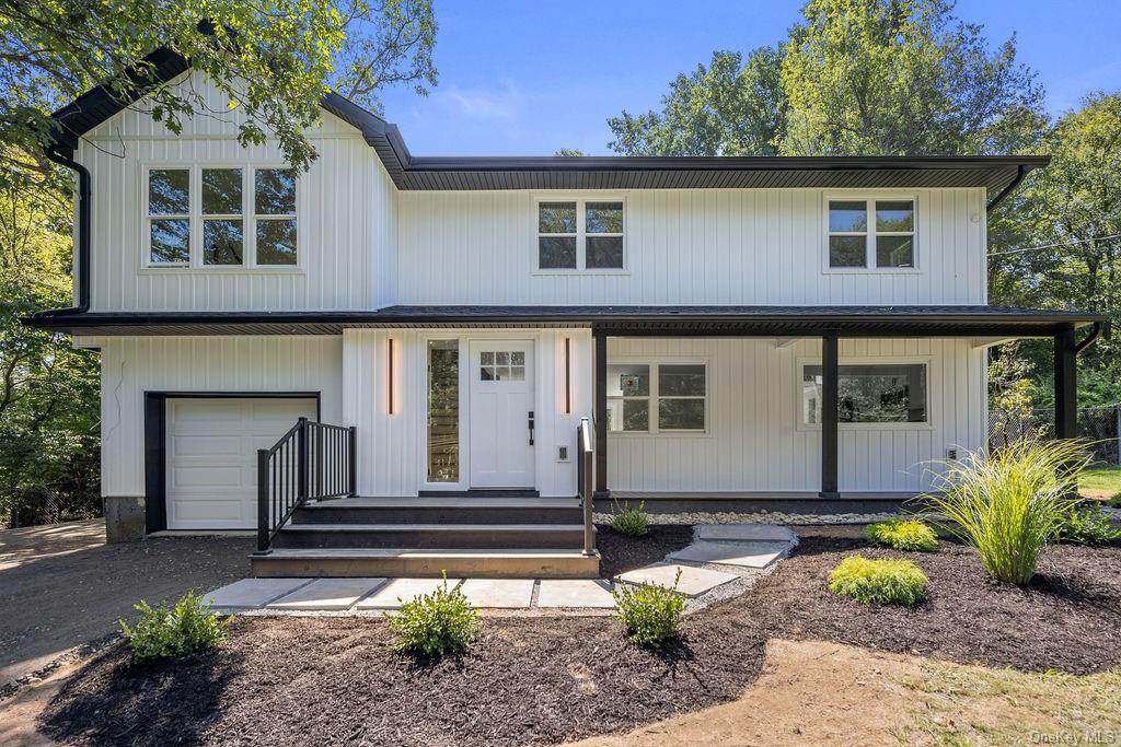 Modern farmhouse style home featuring covered porch and a garage