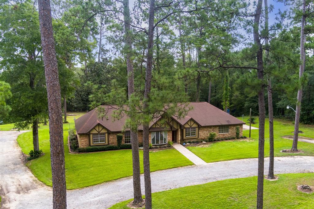 a view of a house with a big yard and large trees