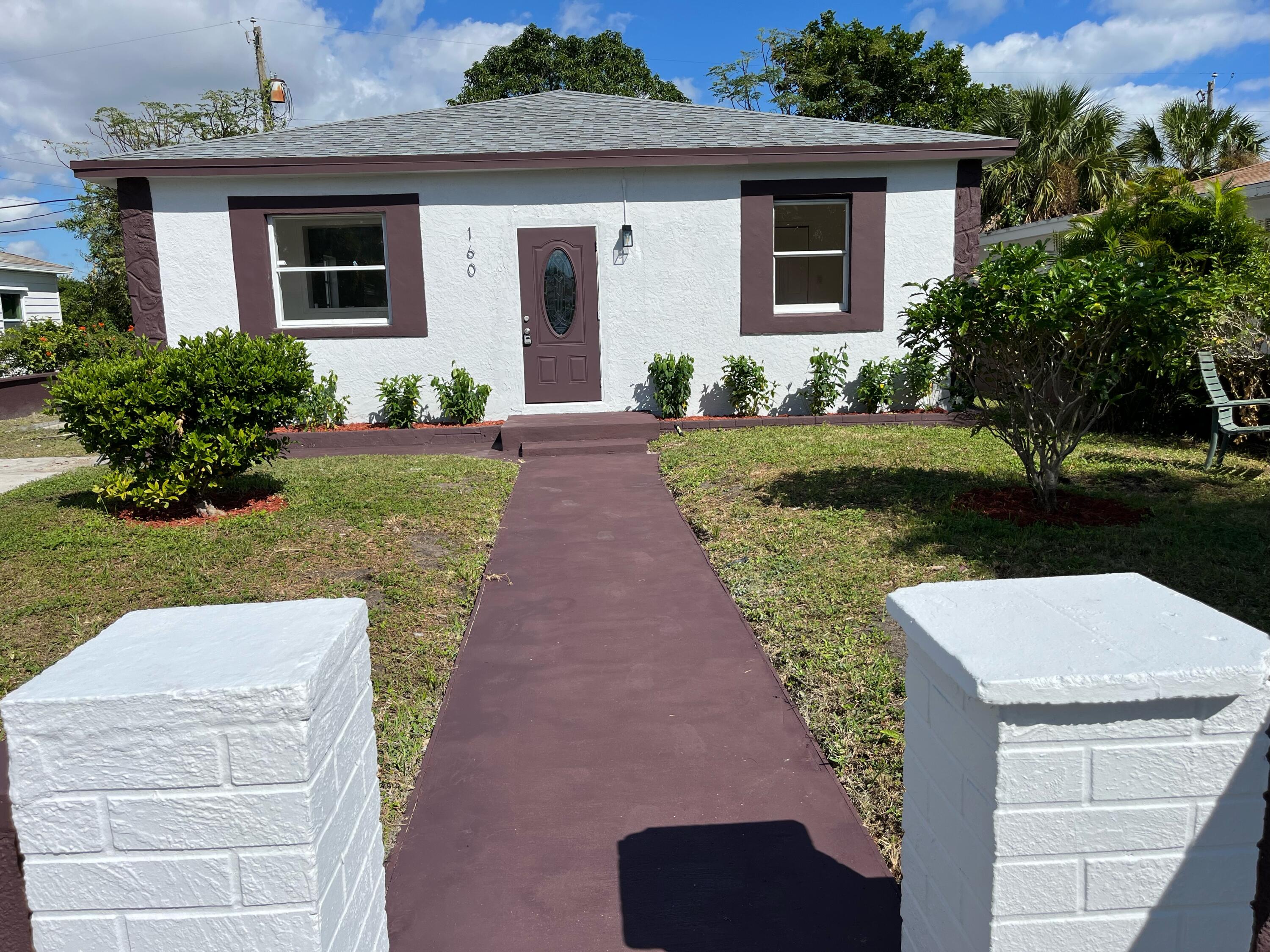 a front view of a house with a garden and plants