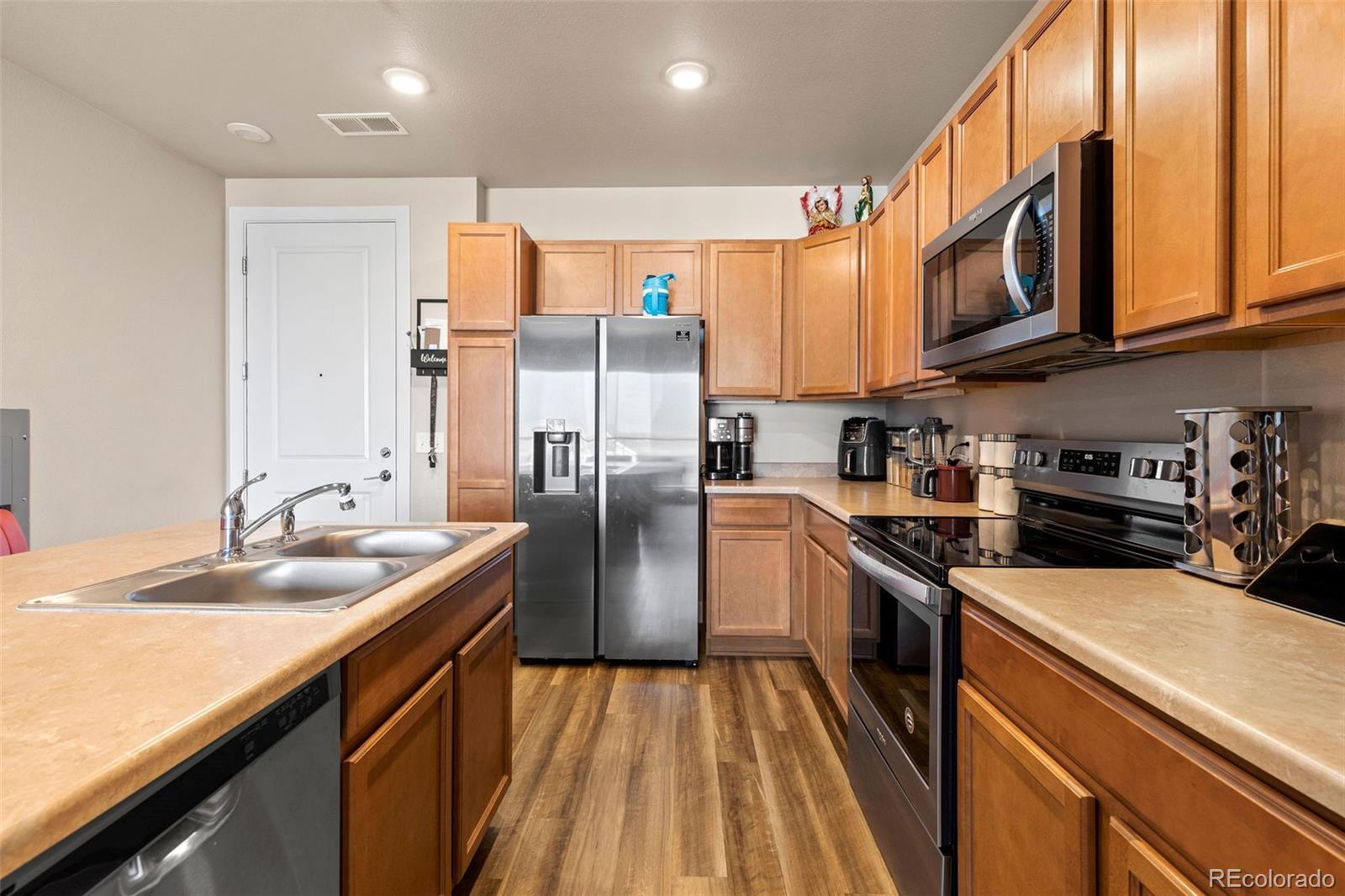 a kitchen with stainless steel appliances granite countertop a sink a stove and refrigerator