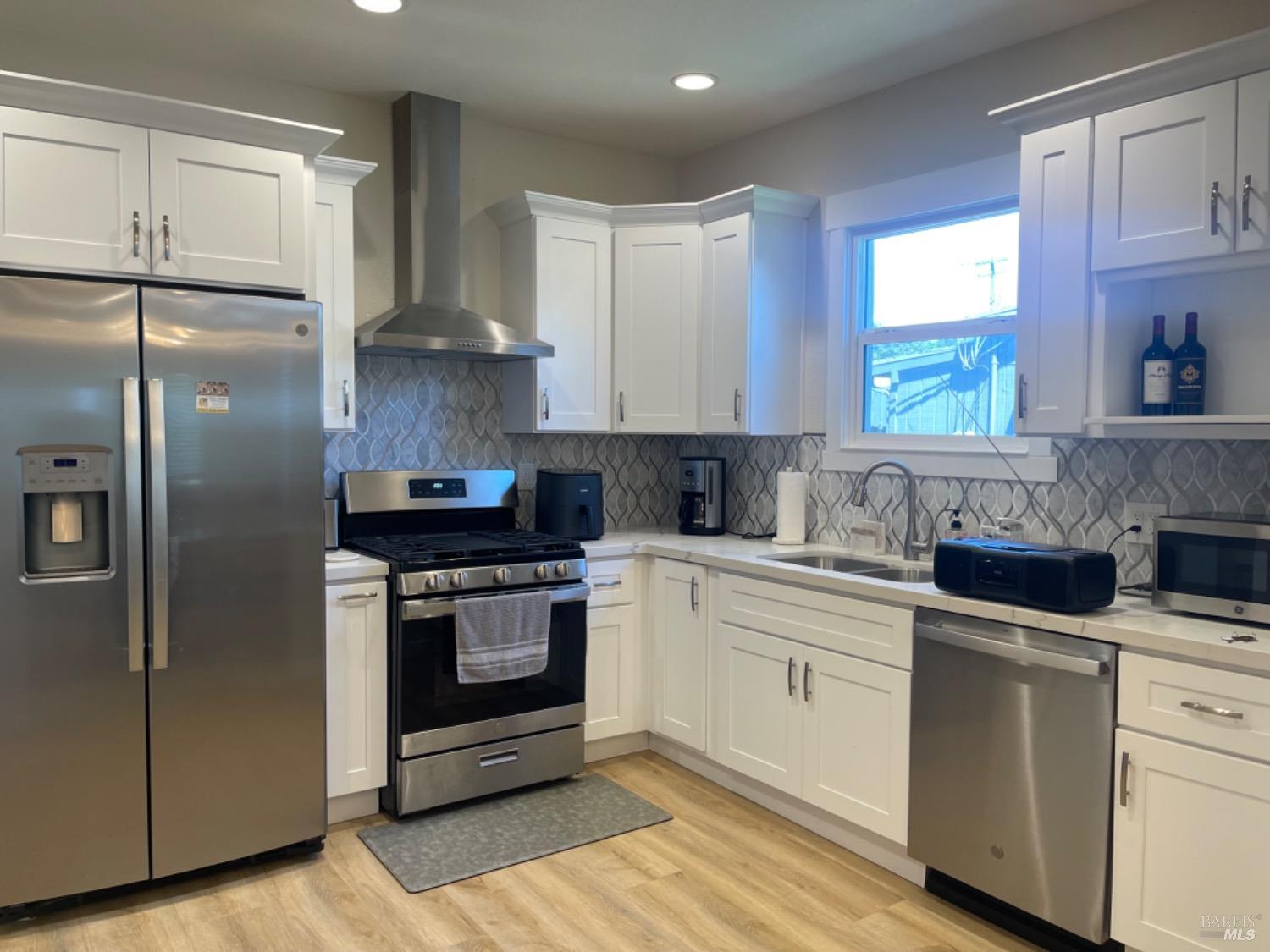 a kitchen with stainless steel appliances granite countertop a stove a sink and a refrigerator