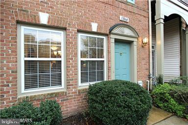 a view of a brick house with a large windows and a potted plant