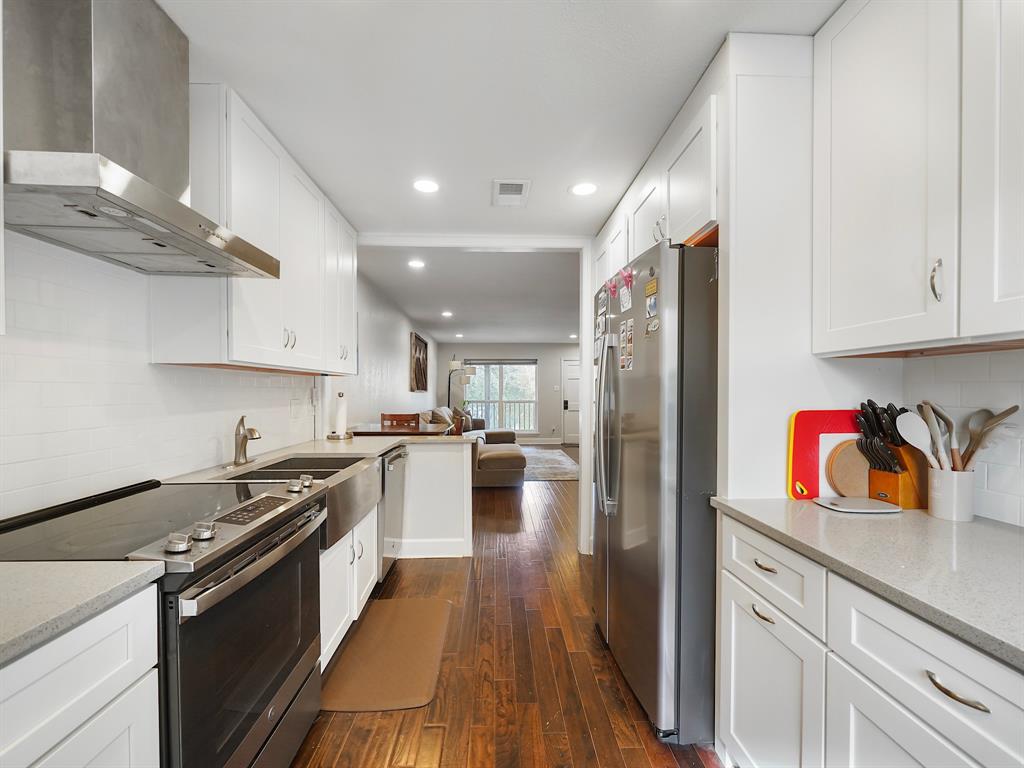 a kitchen with granite countertop stainless steel appliances cabinets a sink and a counter top space