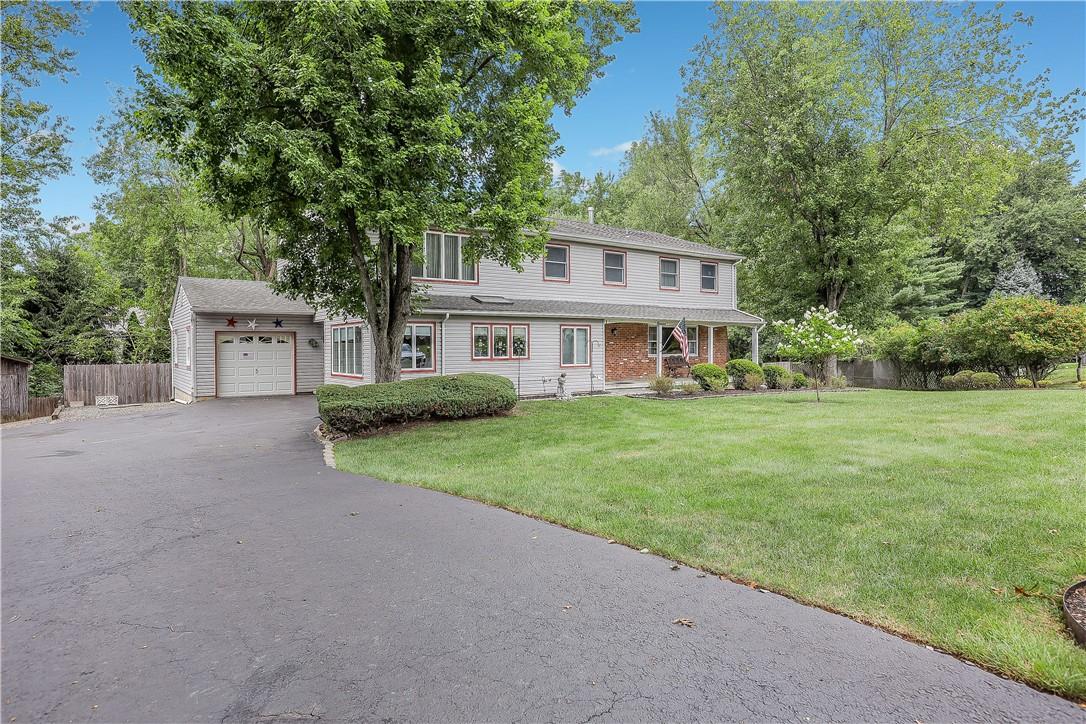 View of front of house with a garage and a front yard and oversized driveway