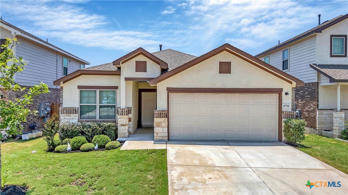 a front view of a house with a yard and garage