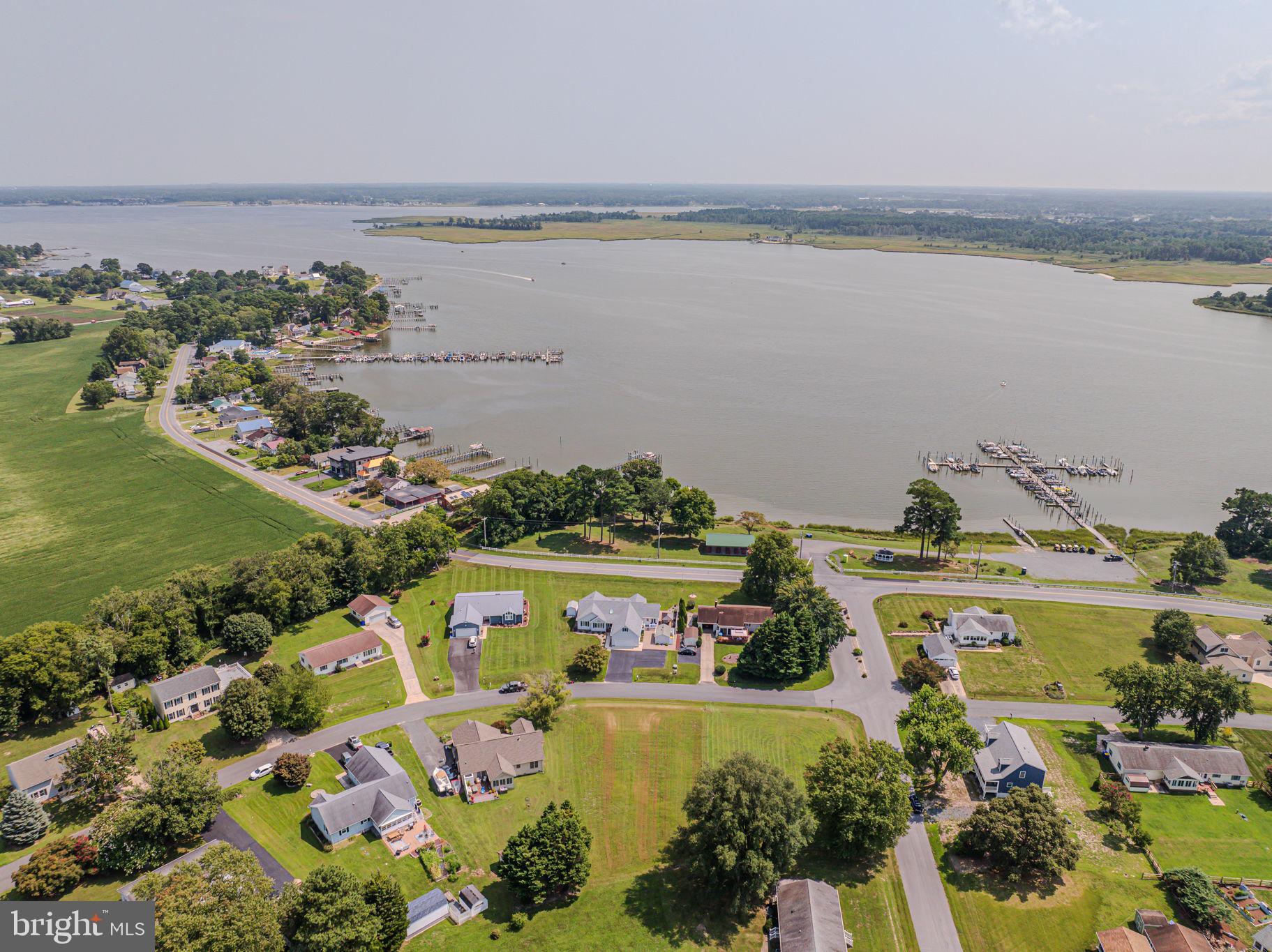 an aerial view of ocean and residential houses with outdoor space