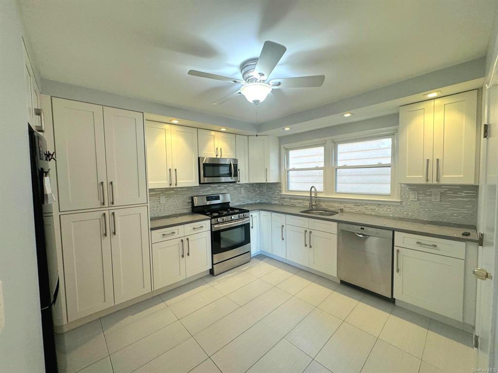 a kitchen with granite countertop appliances cabinets and a sink