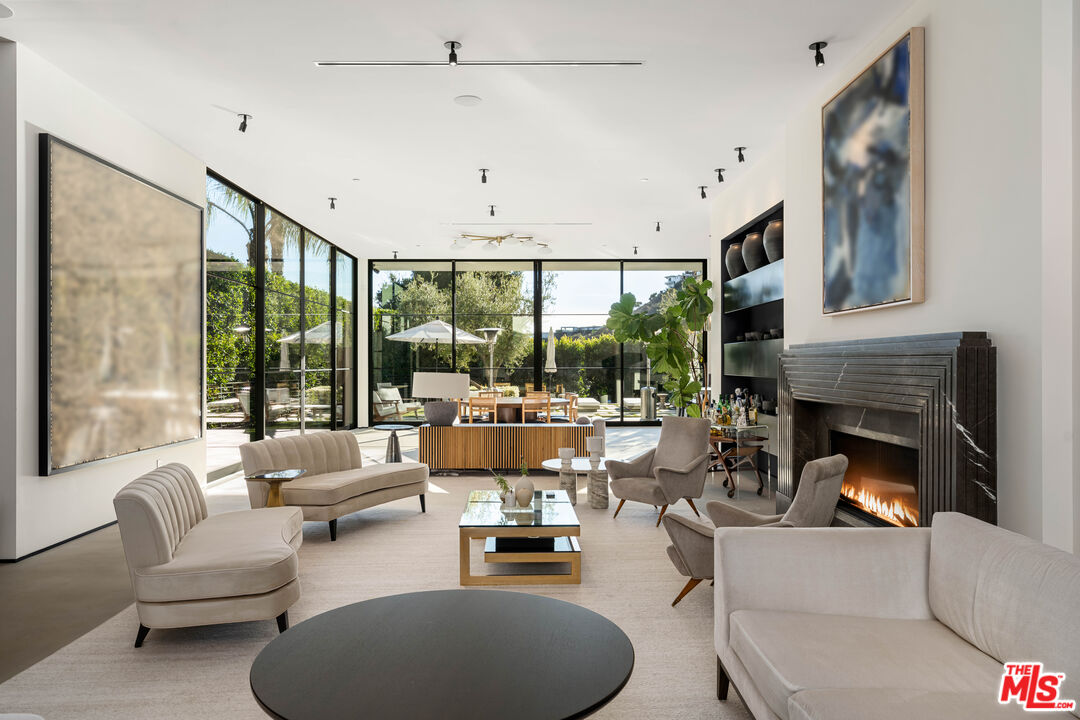 a living room with furniture fireplace and a large window