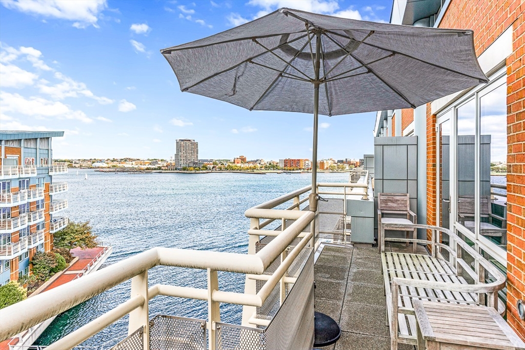 a view of a balcony with chairs and an umbrella