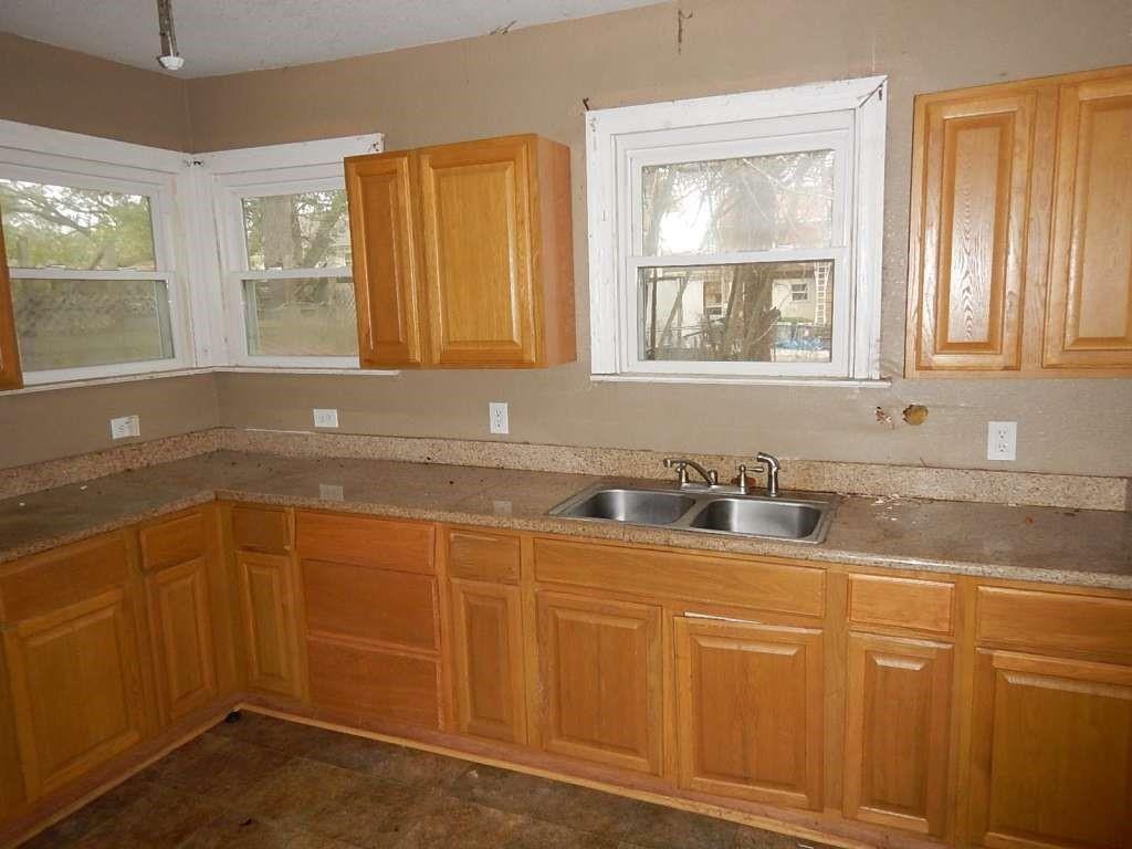 a kitchen with granite countertop a sink cabinets and window