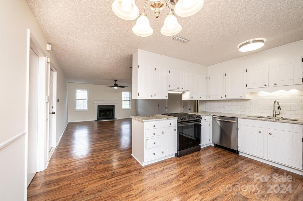 a large kitchen with cabinets wooden floor and stainless steel appliances