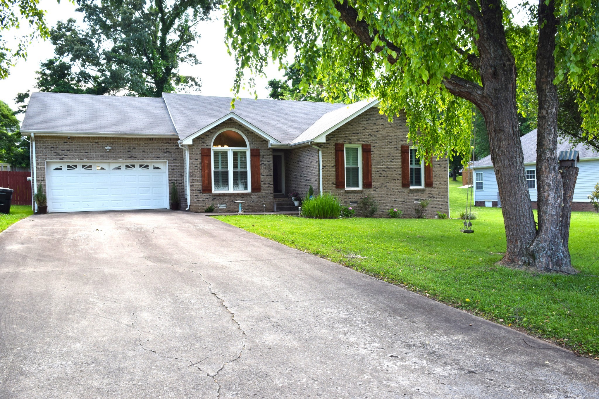 a front view of a house with yard and green space