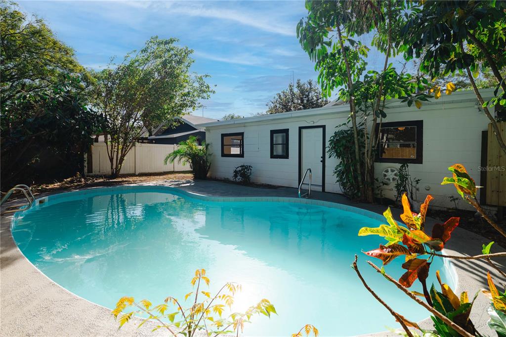 swimming pool view with a garden space