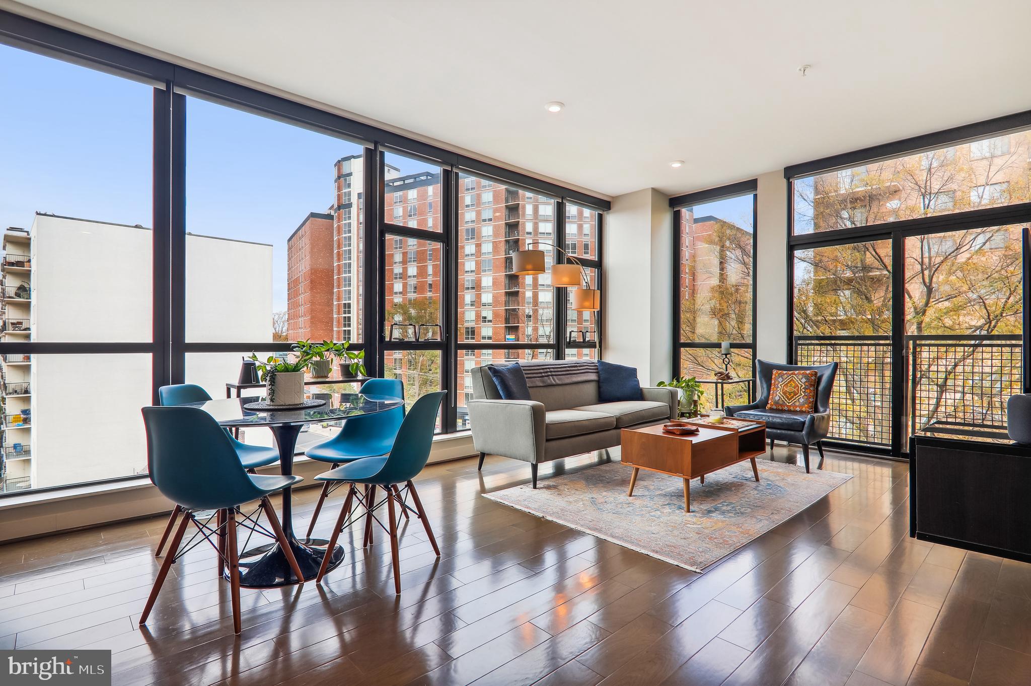 a living room with furniture and floor to ceiling windows